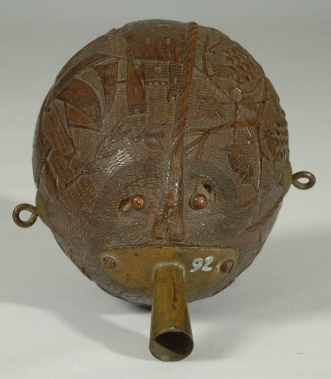 A rare late 19th century British or American carved coconut powder flask with a medieval castle, a galleon, birds, anchors and trees -- surrounded by an intricate fish scale pattern throughout. Most likely a maritime piece - inscribed 'HOPE.'