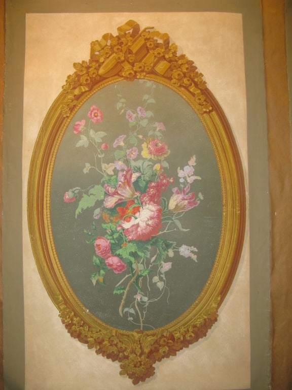 A pair of antique hand blocked wallpaper panels with stylized gold hand blocked ornately designed frames.
Within hand blocked frame are bouquets of richly colored flowers on a greyish background.
Rectangular beige section shown measures 26 1/2