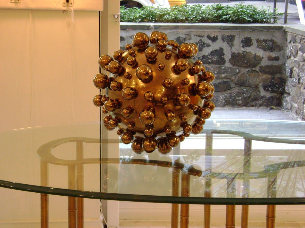 Pamela Sunday creates hand built ceramic sculptures that are inspired by nature and science. This example, titled Globoid, is realized in stoneware with a gold luster glaze, a smaller example (12.5
