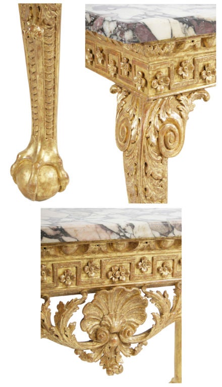 A George II boldly carved marble-topped giltwood console in the manner of William Kent.  The fret and flowerhead frieze over a 
leaf-swagged apron centering a  shell, and raised on acanthus carved  legs ending in claw and ball feet.