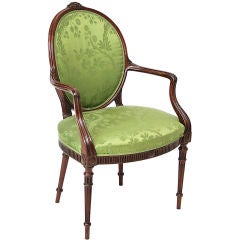A George III mahogany oval-backed upholstered open armchair.