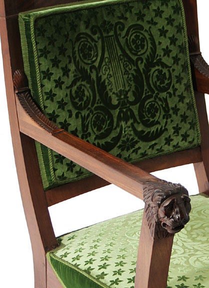 Pair of French Empire mahogany elbow chairs with square backs  and lion mask carved arms over sabre legs ending in paw feet, <br />
covered in gaufraged green silk velvet.  Probably by Jean-Baptiste-Bernard Demay.  The carving of the lion mask is