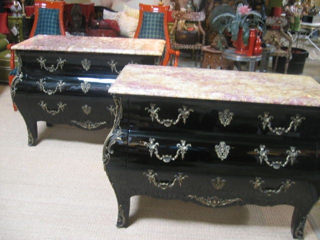 Newly lacquered commodes with bronze doré ormolu mounts. Richly colored marble tops in hues of rouge and golden creams. Each commode has three lockable drawers. The ornate drawer pulls feature individuals in Renaissance clothing and shell design.