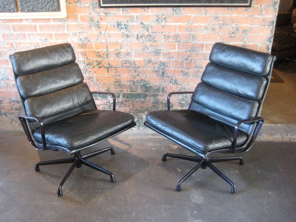 Pair of leather soft pad lounge chairs with eggplant frames