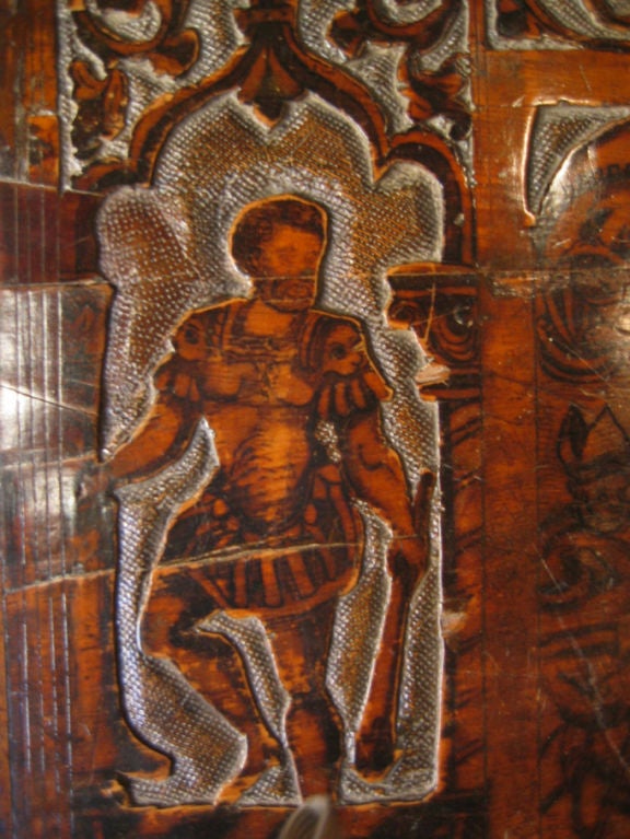 An Italian 17th century cedarwood and cypress small cassone with etched central panel of a King seated on a throne and other decorations with battle scenes, putti and Roman soldiers. From the Alto Adige region of Italy. Such woods were highly prized
