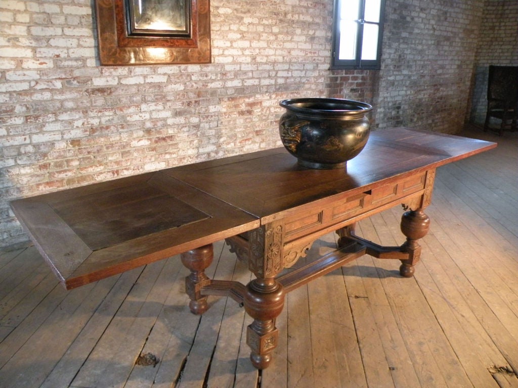 Extension table, lightly carved and with simple bulbous legs, joined by double Y-stretcher.