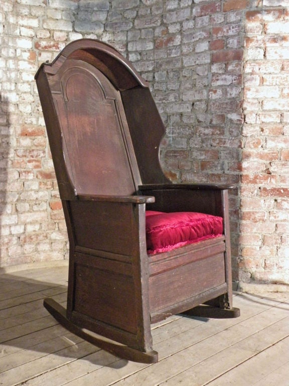 Unique English Oak Rocking or Porter Chair , of paneled and pegged construction, the back and sides enclosed with conforming panels, the back with rounded 