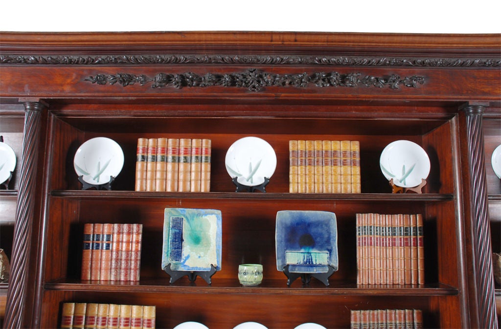 A fantastic quality English library bookcase on a grand scale. The molded cornice with a half-round band of floral and acanthus leaf carving on a dimpled ground. A wide panel of mahogany just below the cornice is centered by crisply executed carving