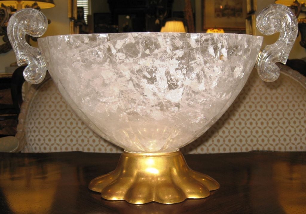 Large scale fluted carved rock crystal oval bowl with scroll handles. The base has a slightly antiqued, brushed finish. There are brass rings where the carved scrolled handles attach to the bowl. This would make a dramatic centerpiece.