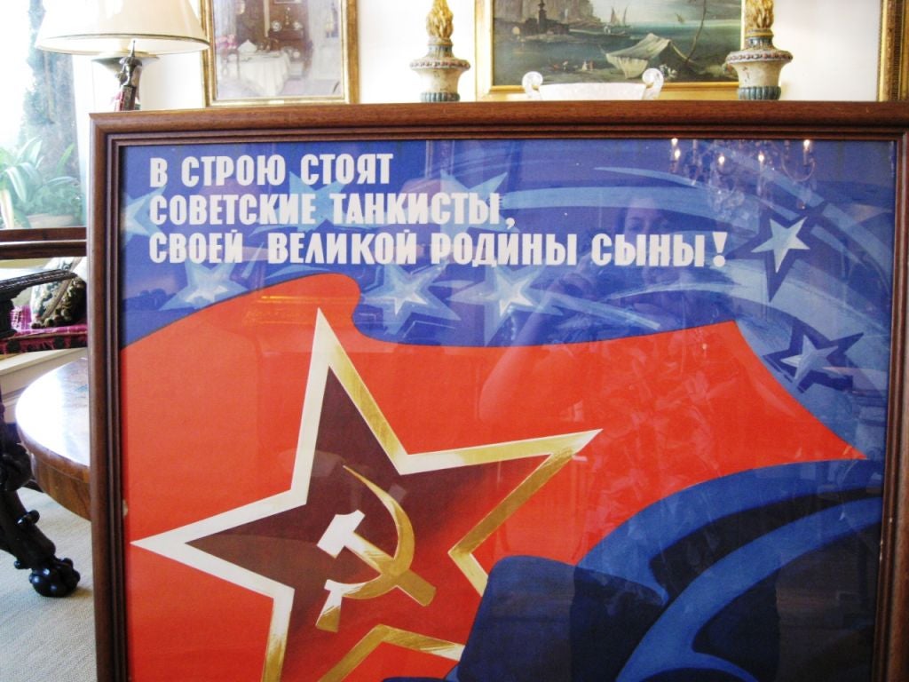 Predominantly red and blue graphic propaganda poster depicting five men in helmets with a large star in the background displaying the hammer and sickle. Printed in Moscow in 1976.