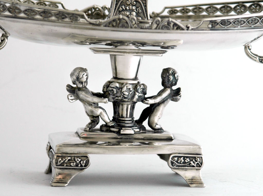 PLEASE VISIT LAUREN STANLEY IN NYC<br />
<br />
A fine circa 1880 silverplate figural centerpiece by Reed & Barton, of Taunton MASS, a 3-dimensional, tall, draped maiden pouring wine into a cup, standing on a platform decorated with fruit,