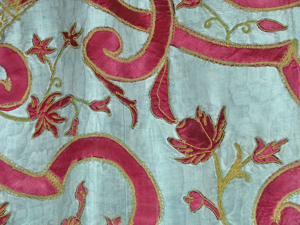 18th century Italian blue silk moire bed hanging with red and yellow silk applique design of interlaced strapwork and scrolls with floral motifs, with red silk knotted fringe on three sides.