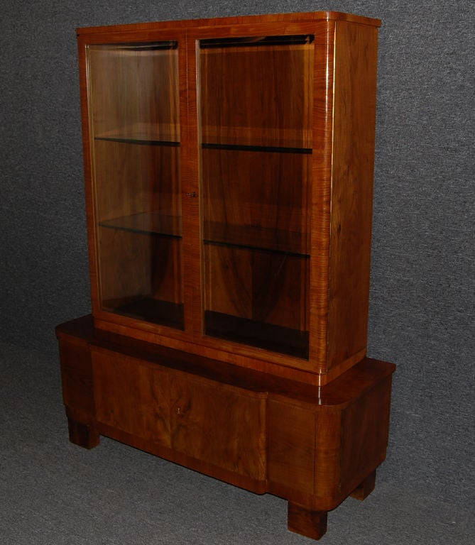 Beautifully crafted glass front cabinet of flame walnut and rosewood.  Fully restored.<br />
<br />
Glass shelves.<br />
<br />
Key included.