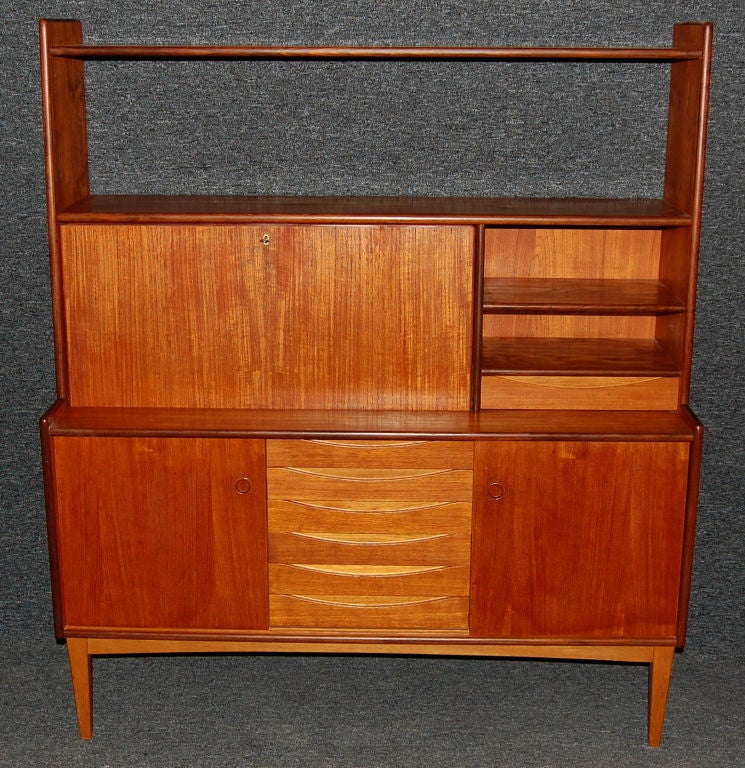Teak credenza with drop-leaf desktop, multiple shelves and drawers. Lower section has two cabinet doors with two interior shelves and six four ample exterior drawers.<br />
<br />
Made in Sweden by Swedish furniture and cabinetmaker Brantorps