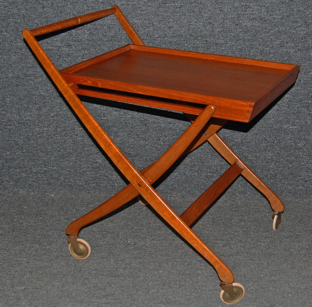 Folding bar, drink or serving cart of natural teak.  Dove-tailed tray is fashioned upon scissor folding legs on wheels. <br />
<br />
Danish Furnituremakers Control sticker on bottom of tray.<br />
<br />
Please contact us with any questions!