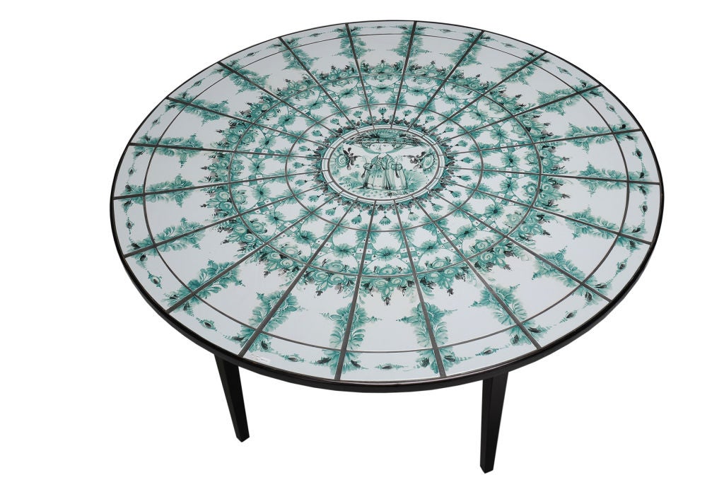 Table by Bjorn Wiinblad<br />
Denmark 1918 - 2006<br />
Circa 1974<br />
Impressive size Bjorn Wiinblad's  table; the circular top with hand-painted and glazed ceramic tile, centered with a classic Wiinblad figure and signed. The outer edge of