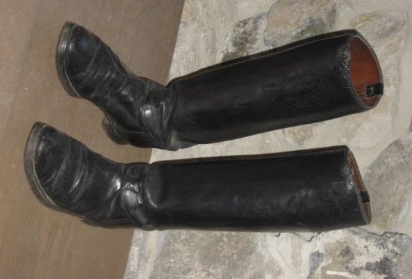 Pair of vintage leather riding boots with braided leather detailing around top of boots.