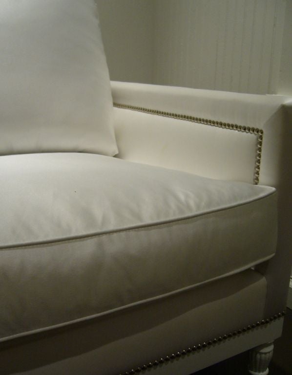 White satin sofa with nailhead detail, from a one of a kind set modeled after specific pieces from Coco Chanel's apartment in Paris. 

