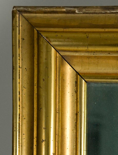 A Mid to Late 19th Century American gilded mirror. Maintains original blue glass mirror.