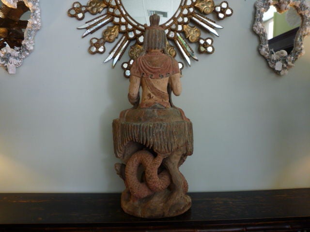 A carved and painted Kwan Yin or Buddha figure, seated on a mythical beast. Old if not original paint.

 