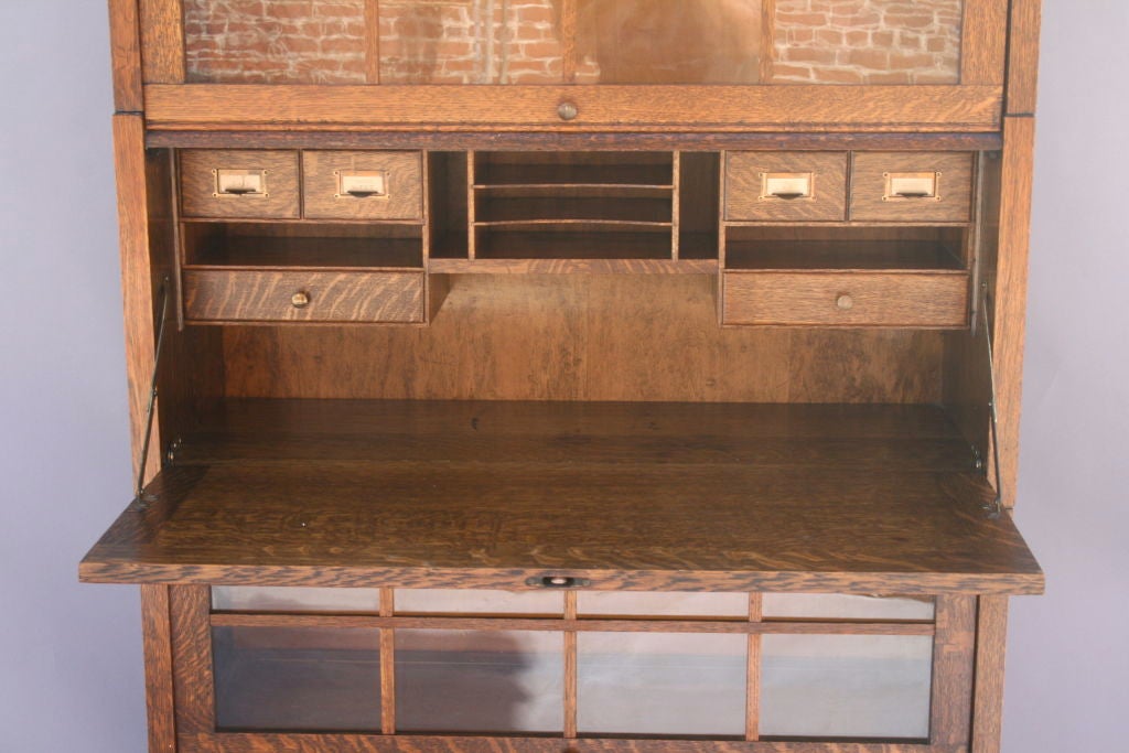 Beautiful Arts & Crafts drop front oak secretary.  Offers enclosed shelving, perfect for books or displaying for curios.   Drop front design closes desk for clean appearance.