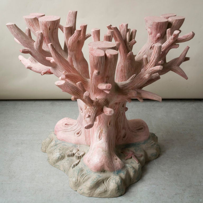 An unusual carved and painted wood table base in the form of a tree trunk on a rocaille carved base, coral colored on a green / blue base
