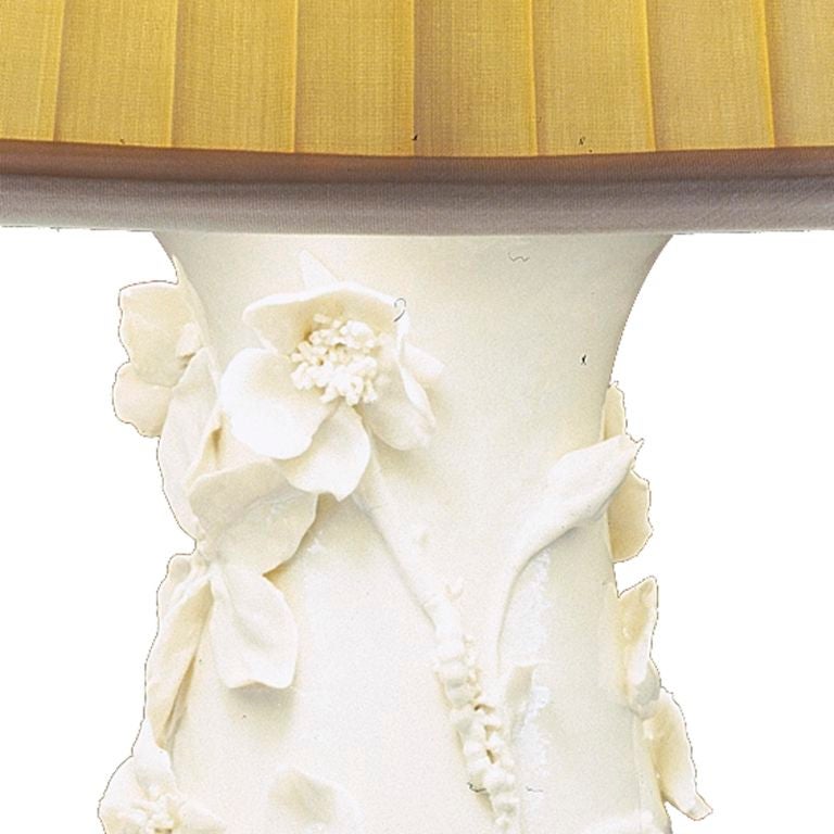 A white porcelain lamp of teardrop form with applied flowers and caterpillars, with a clear glaze.