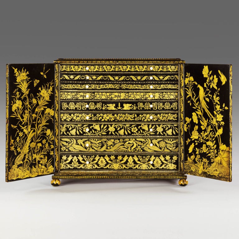 A rare and unusual Regency penwork cabinet decorated on the front and sides with genre chinoiserie and on the top with geometric designs. The doors open to reveal an interior of varied height drawers each decorated with different neo-classical