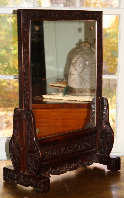 A hand carved dark native hardwood table-top screen frame,<br />
converted to a dressing table or shaving mirror.