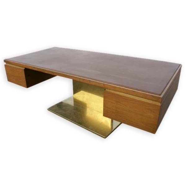 A desk and credenza designed by Warren Paltner for Lehigh-Leopold in 1970.  These impressive mid century modern pieces are made of walnut and are raised on brass plinths.  The desk has a leather writing surface, two large leather lined file drawers,