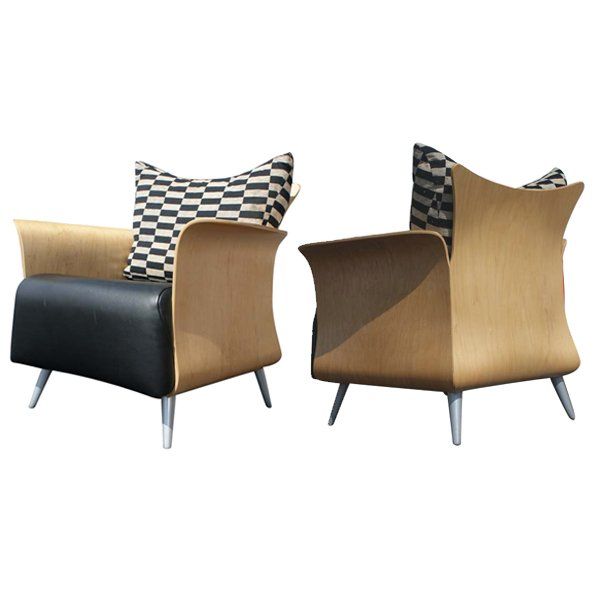 A pair of mid century modern Belle chairs designed by Tom McHugh for Keilhauser.  A stylish design in molded maple with flared arms and back.  The seat is upholstered in black leather.  The loose back cushion is upholstered in black and silver