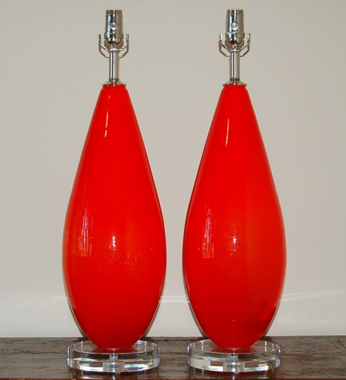 Large Chinese red vintage Murano lamps attributed to Venini. An eye-catching color, to be sure, but the sleek, smooth glass surface adds to their beauty!

These lamps measure 28 inches high from tabletop to socket top. As shown, the top of shade