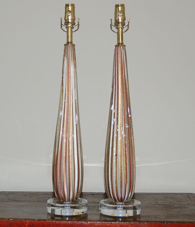 Ribbed, slender columns of Murano glass with a PLUM/LAVENDER striping.  GOLD DUST is sprinkled liberally throughout the glass.

The lamps are 27 inches tall from tabletop to socket top.  As shown, the top of shade is 33 inches high.  Lampshades