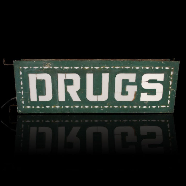 This is a wonderful double sided Drugs sign from the 1920's era. The metal can sign has Milk glass panels behind each letter and is lit by three light bulbs. The finish appears to be original, as is the wiring and the mounting bracket.<br />
<br