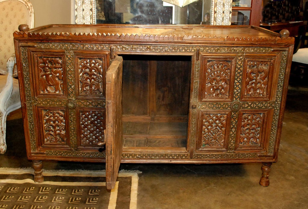 Pakistani finely carved two door dowry chest, front with carved inset panels depicting a variety of animals, foliate and geometric designs, original hardware, front with turned legs and back with carved bracket feet.
