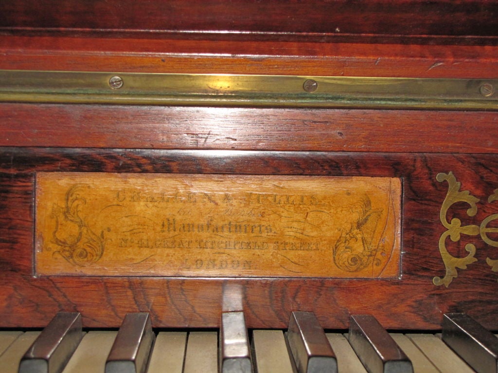 19th century English upright piano with brass inlaid design above the key board and candle holders on each side of the key board. This piano is very decorative and has the manufacturer label on it which I believe to say 'C. Hallen & Gillis'