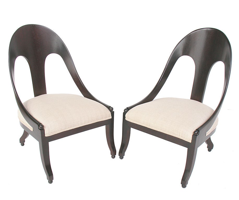 Sculptural Pair of Spoon Back Chairs, circa 1950's. These sexy low slung chairs look great from every angle! They are executed in a deep brown finish over the walnut frames, with ivory colored linen upholstery. Price quoted in this listing if for