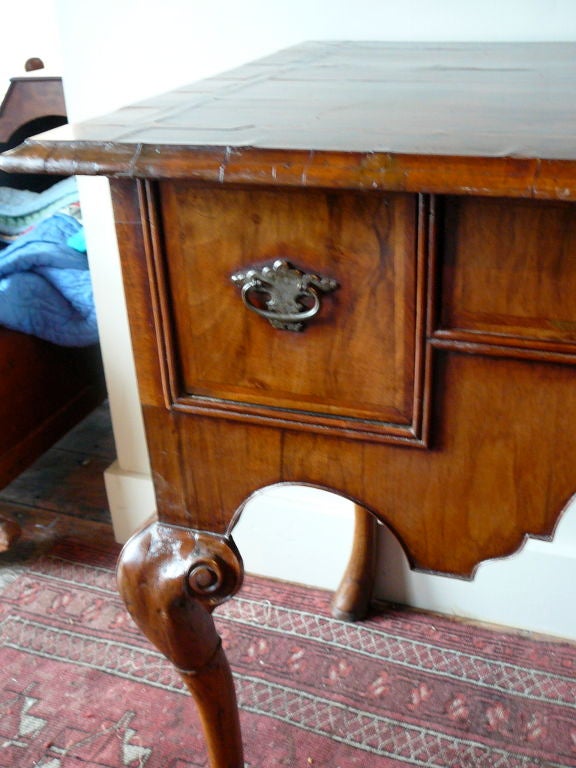 Early 18th Century Queen Anne Period Lowboy. Molded top with quarter “bookmatched” Black walnut veneers, feather banding, and crossbanding. Three drawers over shaped apron and extraordinary cabriole legs with carved hoof feet. Made in England circa