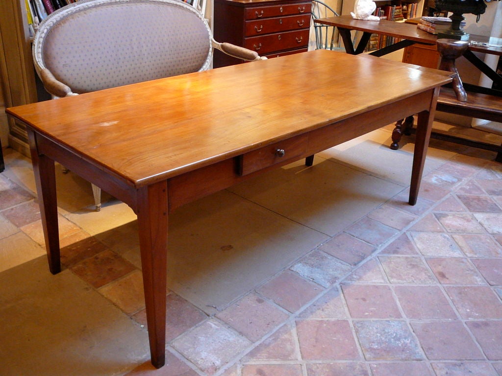 French Provincial Farmhouse Dining Table or writing table made of golden colored pearwood. Large bread slide and single drawer over molded apron with straight tapering legs   Normandy c. 1860