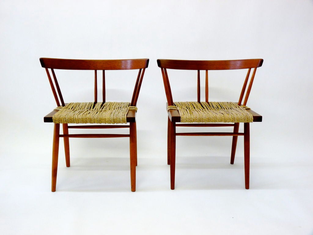 Pair of cherry and walnut George Nakashima grass seat chairs.