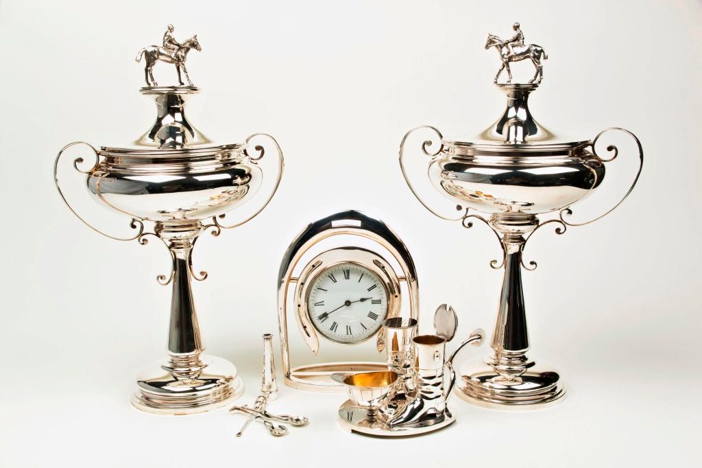 A close pair of Sterling silver trophies with well articulated finials in the form of jockeys on thoroughbreds each made by silversmiths Walker and Hall of Sheffield, England in 1925 and 1927. Each 15.25 inches high.<br />
<br />
A very attractive