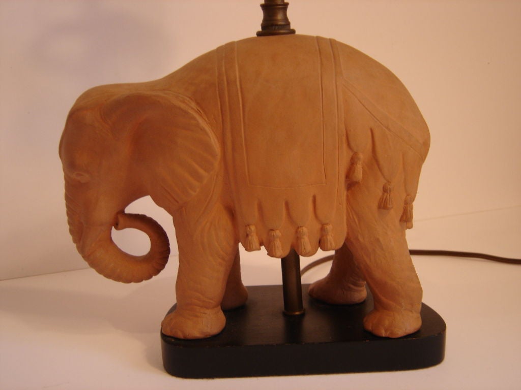 Terracotta table lamp in the shape of an elephant on a black wooden base