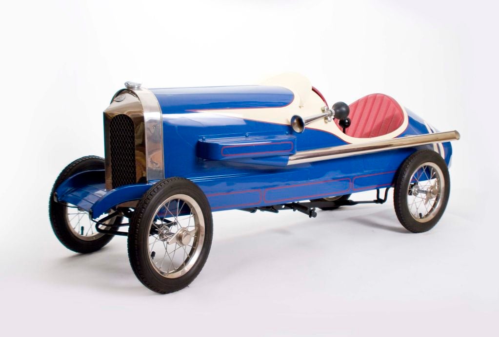 This excellent example of a 1930 pedal car was manufactured by the Toledo Super Quality Line. This particular car is item #3136 from the toy company. The chasis is a royal blue with white trim and numbers. The interior is red with a yellow dash and