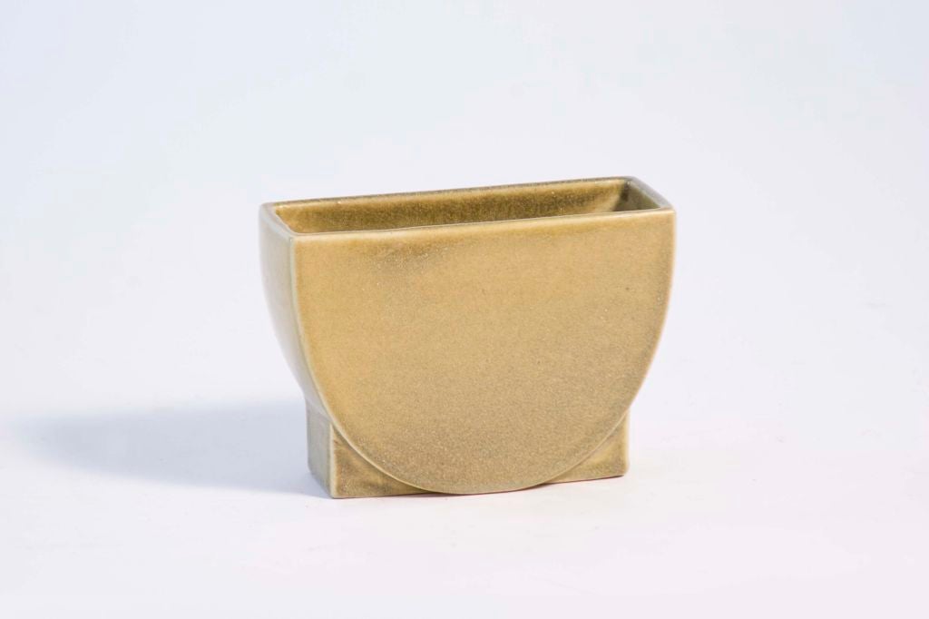 A nice arts and crafts form in a rare yellow glaze. This diminutive planter is signed numbered 1047 on the bottom.