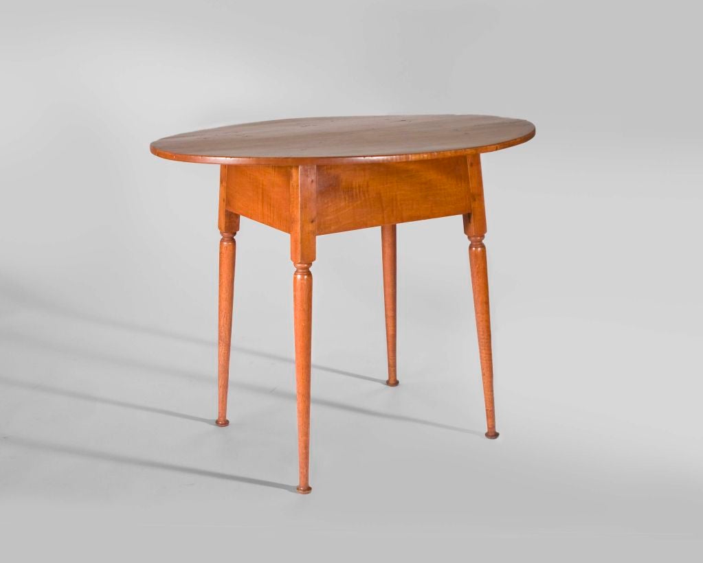 Has an oval top with a red wash finish and turned splayed legs on button feet.