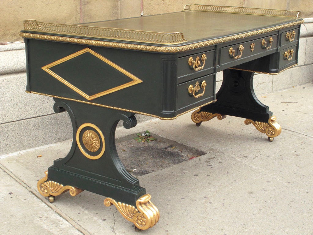 Important William IV period green-painted and parcel-gilt writing desk. The tooled green leather-paneled top fitted with a gilt-brass pierced gallery at each end. One side fitted with five drawers, the other side similarly fitted with false drawers.