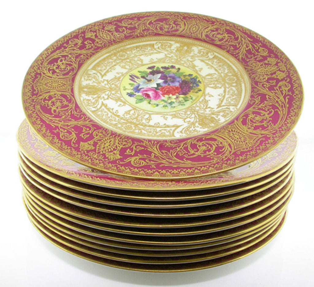 A magnificent set of 12 entirely hand-painted Royal Worcester service plates. Each plate, an elaborate work of art in its own rite, featuring different floral scenes in the center framed by a warm cream border with heavily raised rich intricate gold