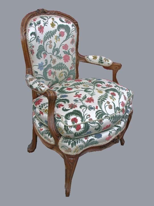 Pair of Louis XV beech Provincial fauteuils with carved molded frames and floral crested toprails  Upholstered  in floral cut velvet on cabriolet legs,  and with scrolling arms.