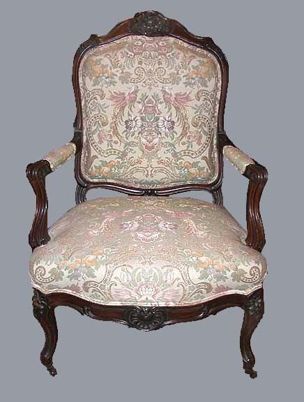Pair of Victorian walnut armchairs with carved foliate crested channeled back and partially padded arms with c-scroll on forward swept arms; the  seashell centered seat rail continues to the cabriole legs ending in casters.
The later fabric has a 