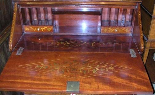 Mahogany and marquetry serpentine front drop leaf secretary opening to reveal assorted cubbies and two side drawers, over three drawers resting on cabriole legs.